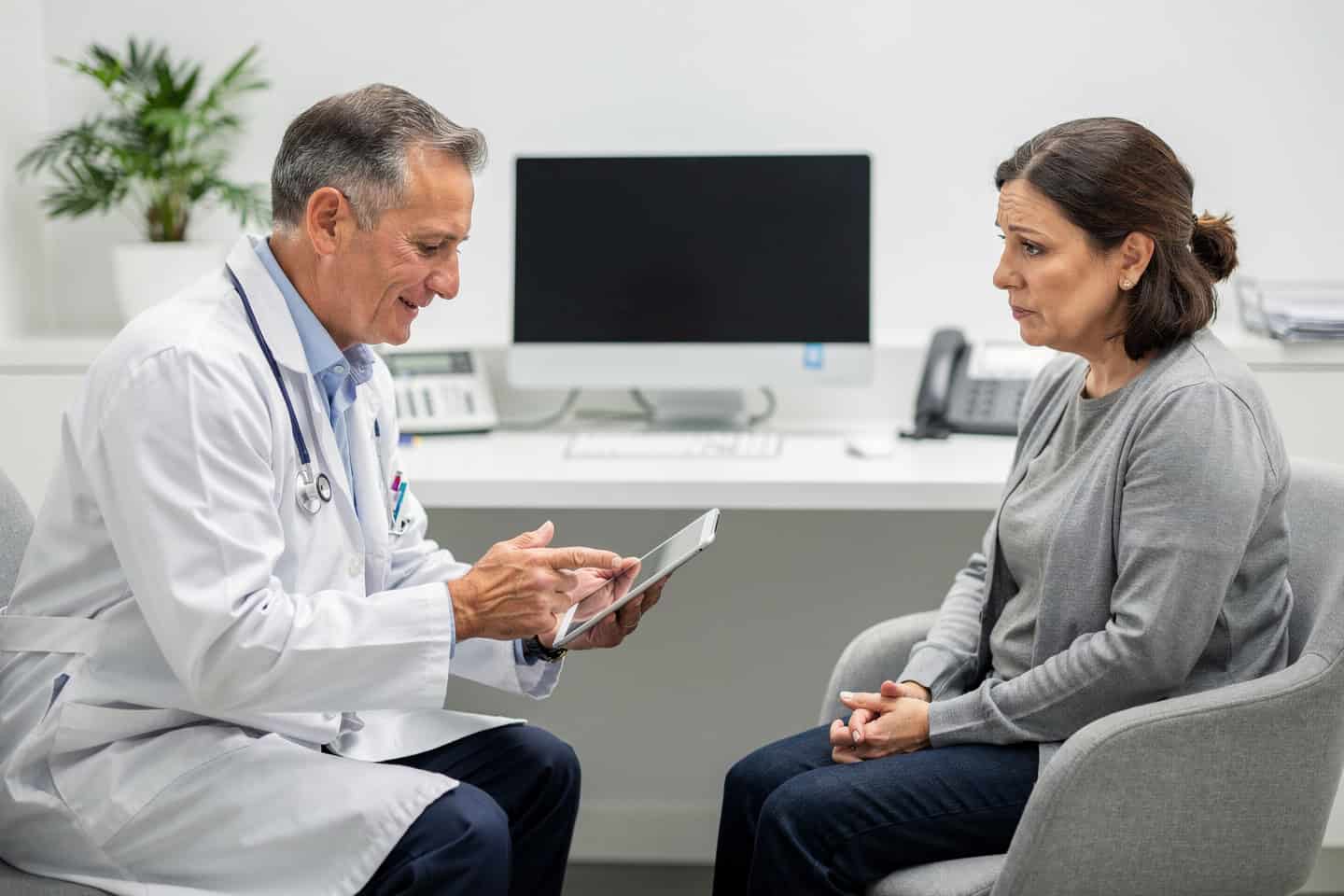 Doctor explaining Digital Pathology Consultation to a worried patient during an office visit.