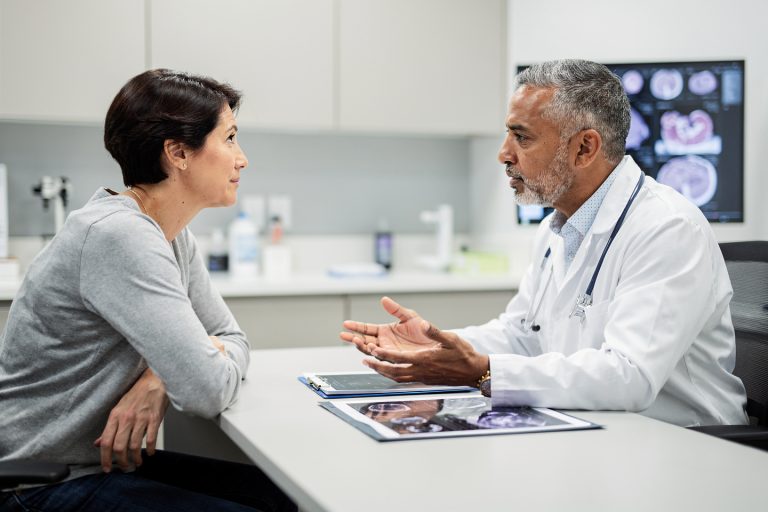 Doctor explaining how a pathology second opinion differs from an oncology treatment review.