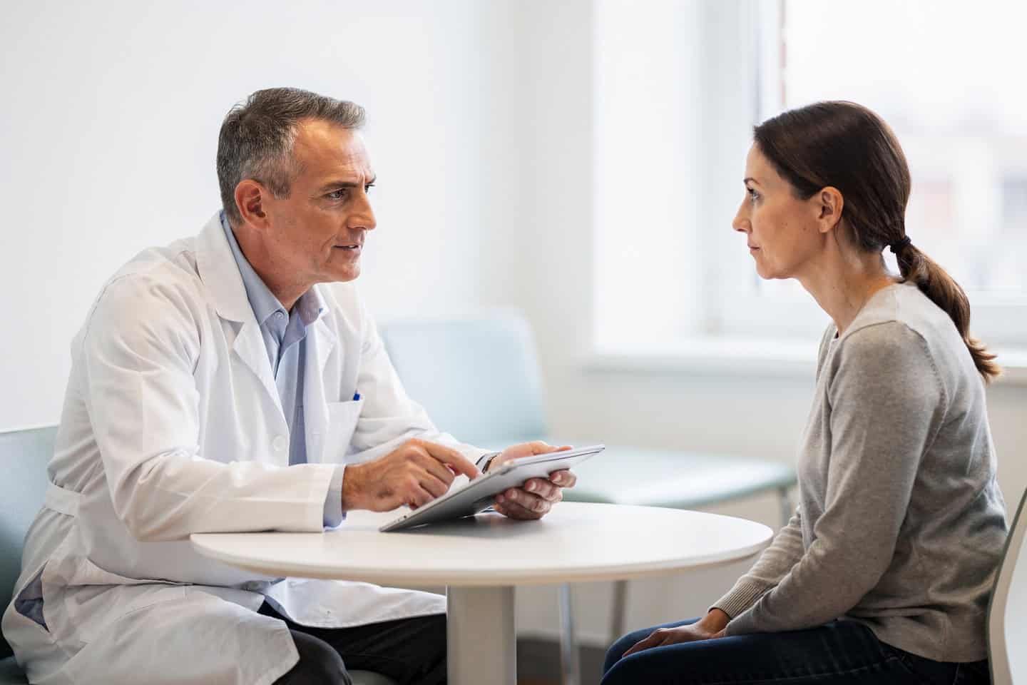 A doctor explains Subspecialty pathology diagnosis to a patient reviewing medical results.