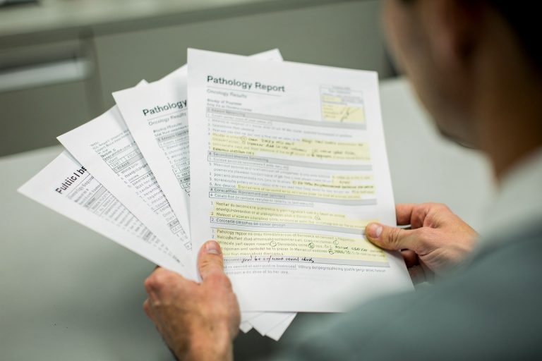 Pathology report pages and medical records highlighting signs you should get a cancer diagnosis second opinion