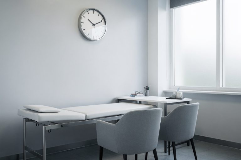 Empty consultation room with a wall clock representing how long a consultation at HONEST Pathology takes