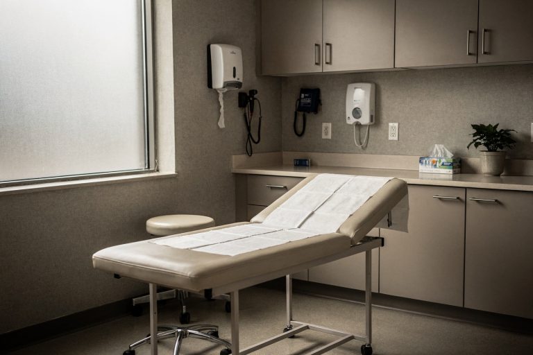 An empty oncology exam room representing whether to wait for a second opinion before treatment.
