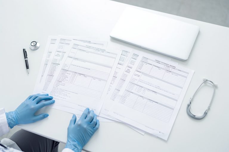 Pathology report pages and medical records prepared for an urgent pathology consultation with no face visible